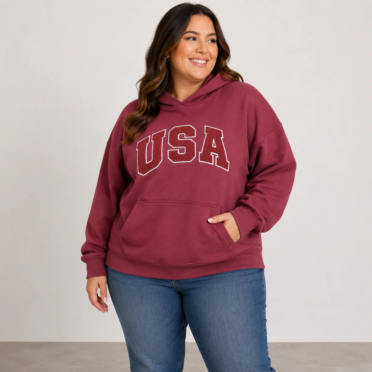 Woman wearing a maroon hoodie with 'USA' text on a plain background
