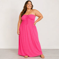 Woman wearing a pink strapless dress against a white background