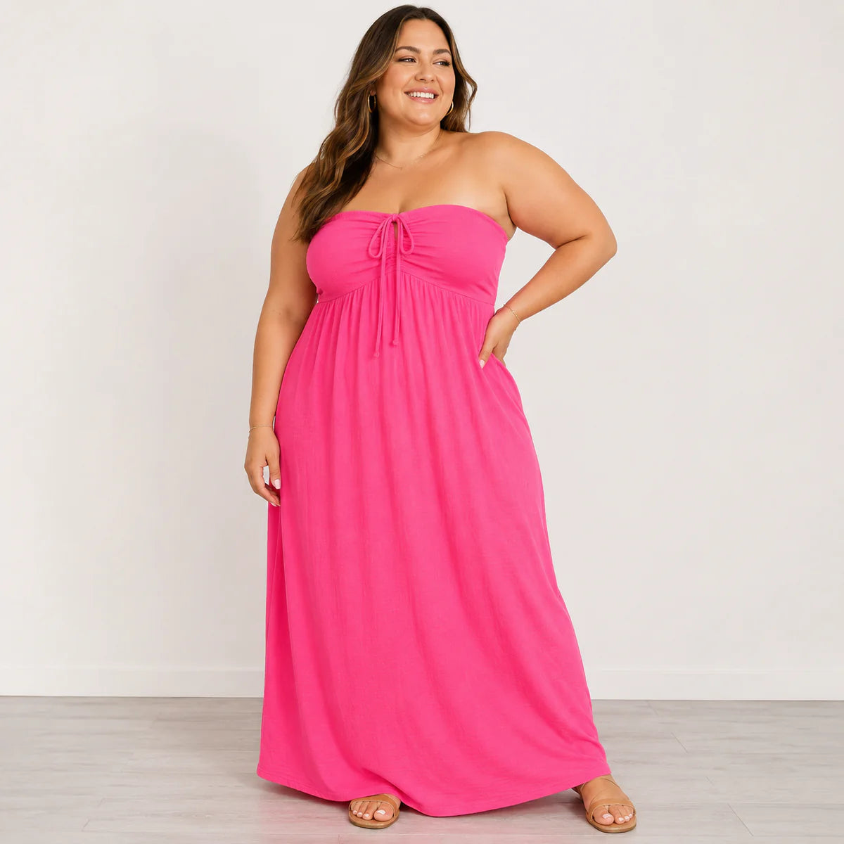 Woman wearing a pink strapless dress against a white background